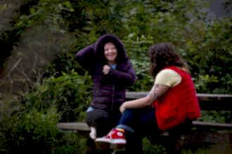 Two people sat at picnic bench in Walthamstow Wetlands